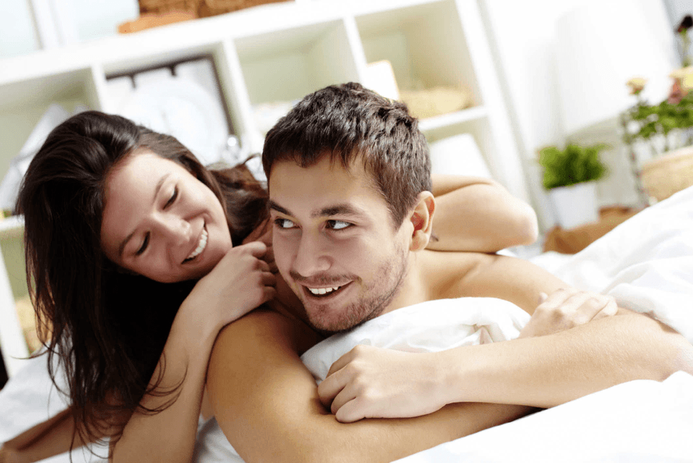 woman in bed with a man who raised his tail with a nozzle
